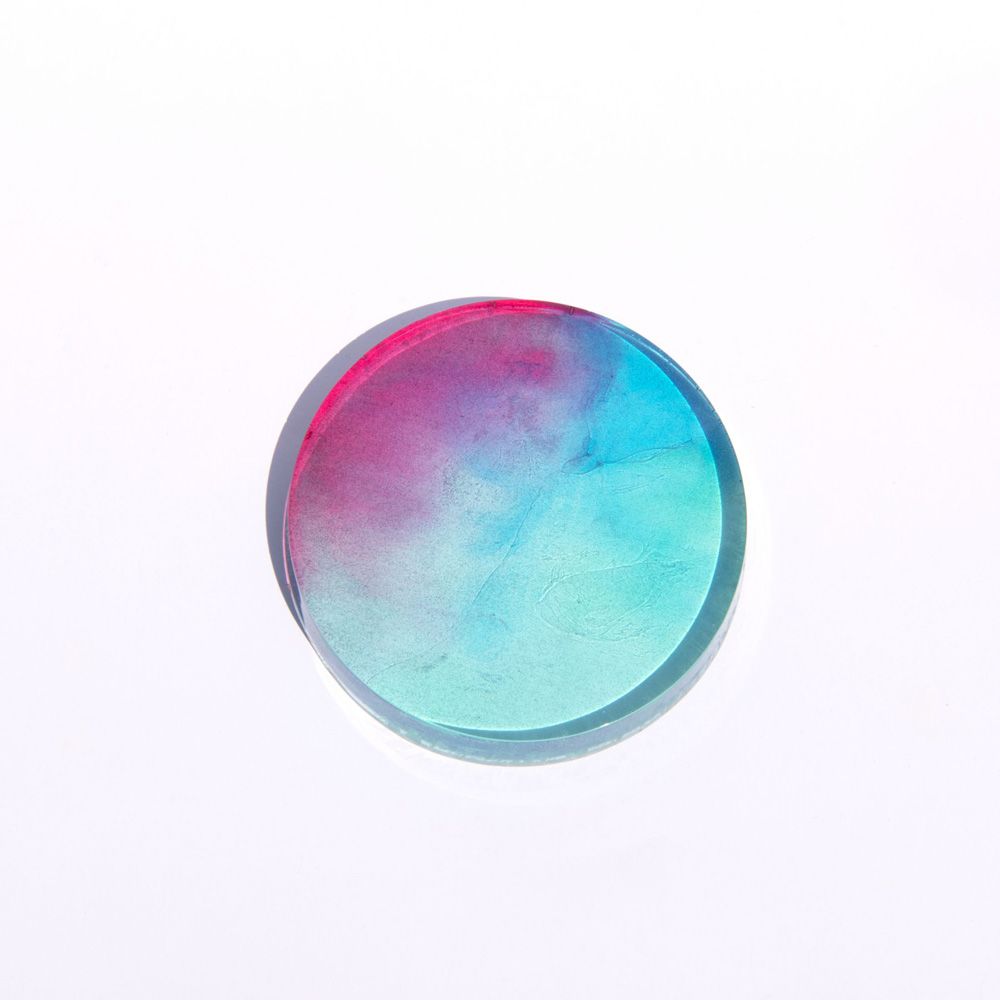 Photo of a petri dish, with the colours baby blue and pink