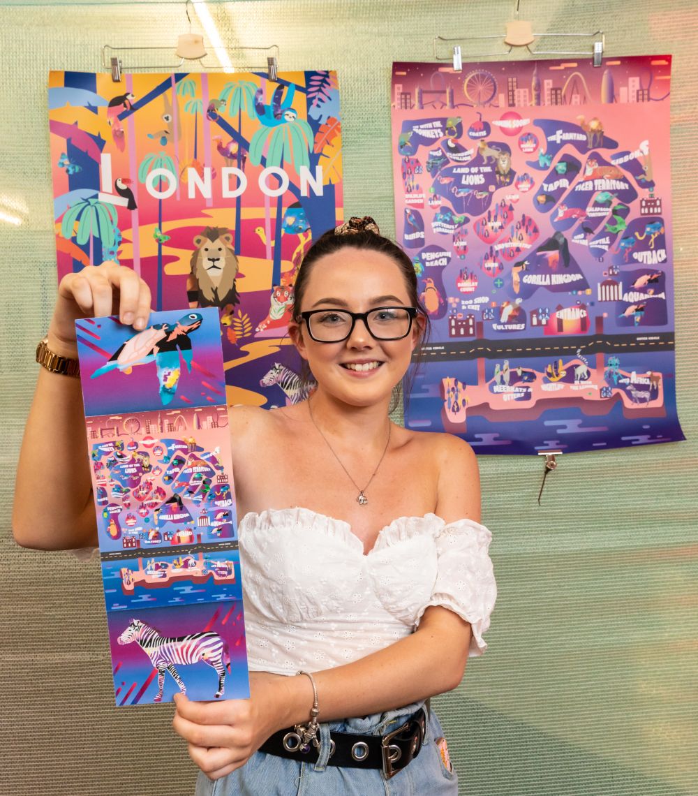 A student prize winner poses with their artwork