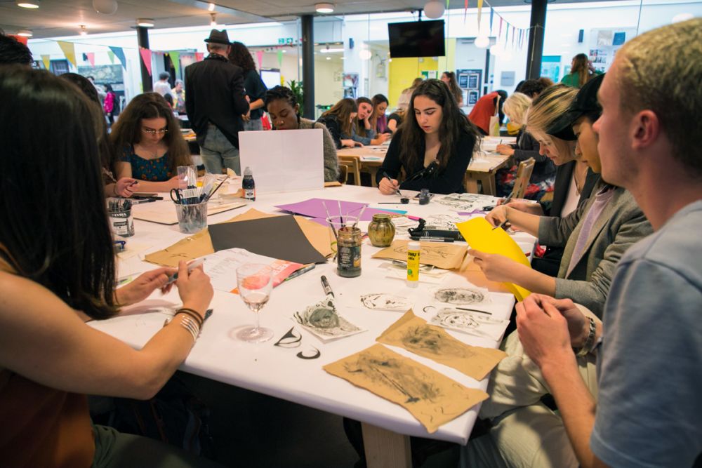 Students taking part in an Illustration workshop around a table