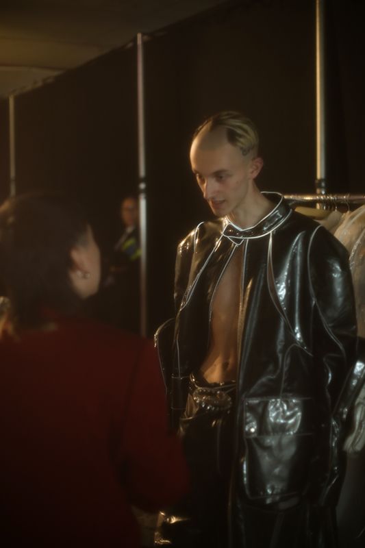 Male model in perspex jacket being dressed