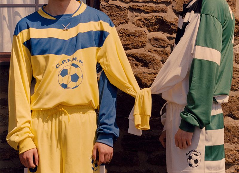 Photograph of models holding hands in a football outfit