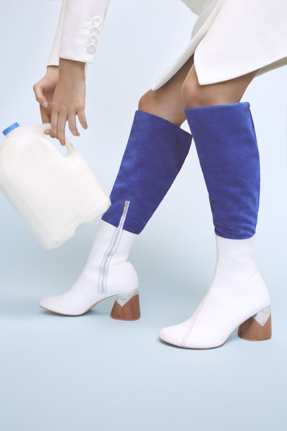 Image of white leather heeled boots worn with colbalt blue trousers and matching white hand bag