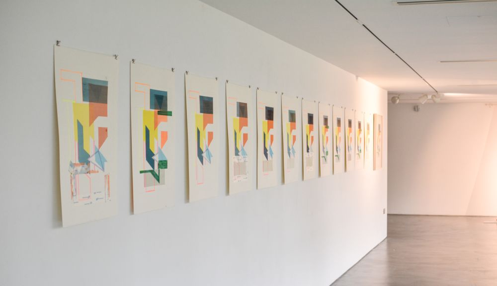 Multiple replicas of the same drawing hung up on a gallery wall in a row