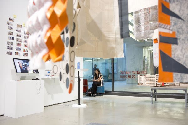 Photograph of the exhibition in the gallery of someone looking at work