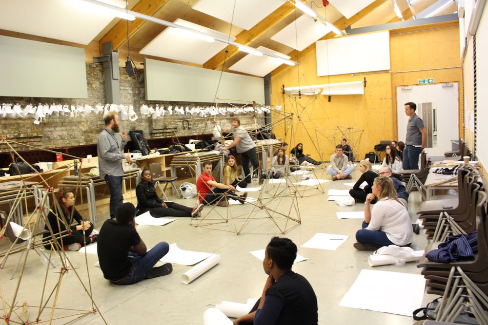 Full shot of the classroom with participants sitting on the floor