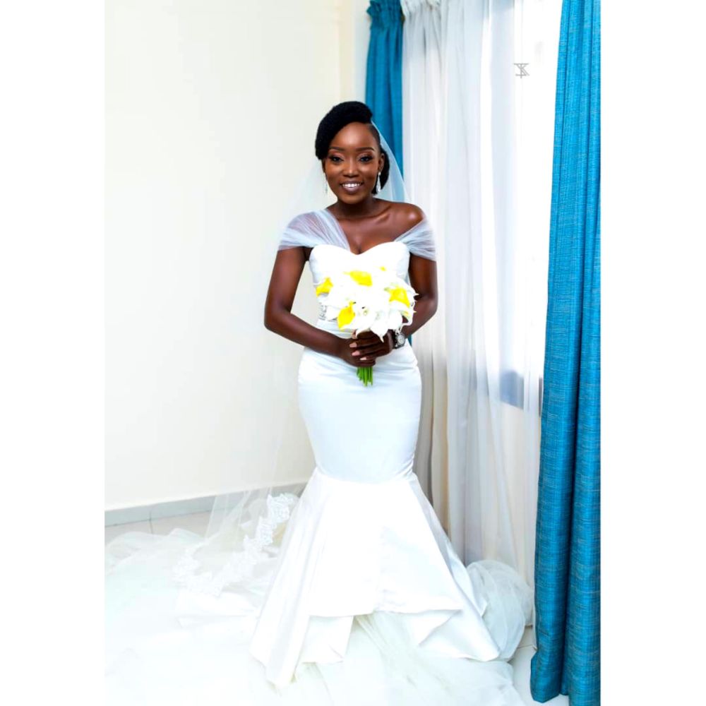 Woman wearing white wedding dress, designed by Tope