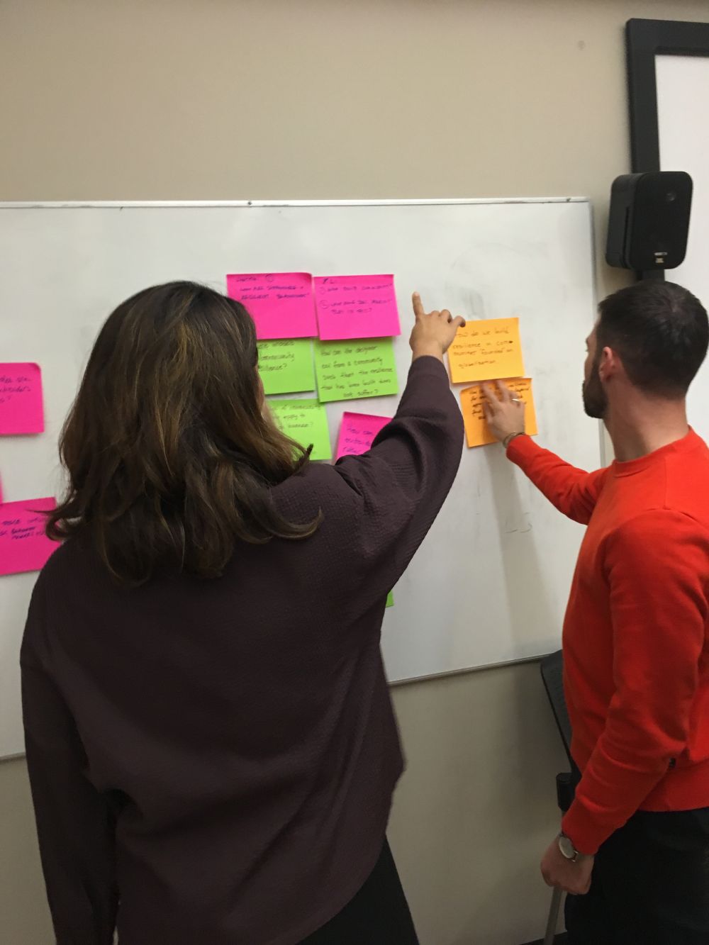 Students putting post-it notes on the white board