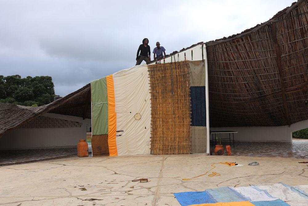 side of makeshift building with people standing on the roof