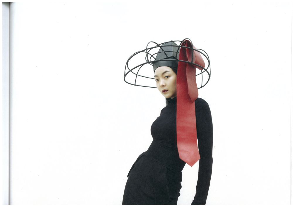 Model with metal framed hat on head with red detailing