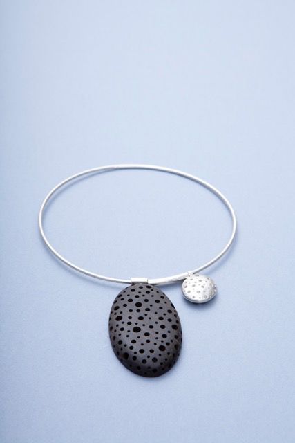 Sarah King's jewellery design, pebble and silver sphere shapes on a bangle.