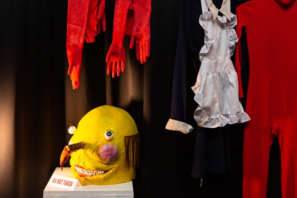 Props for a student animation, including a yellow head, hangin red gloves and a red body suit.