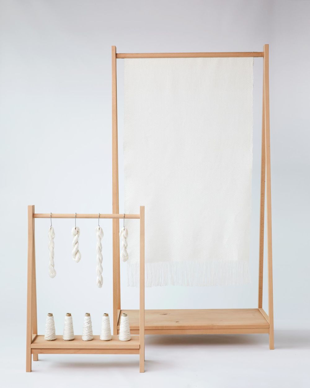 Fabric and thread hanging from wooden frames