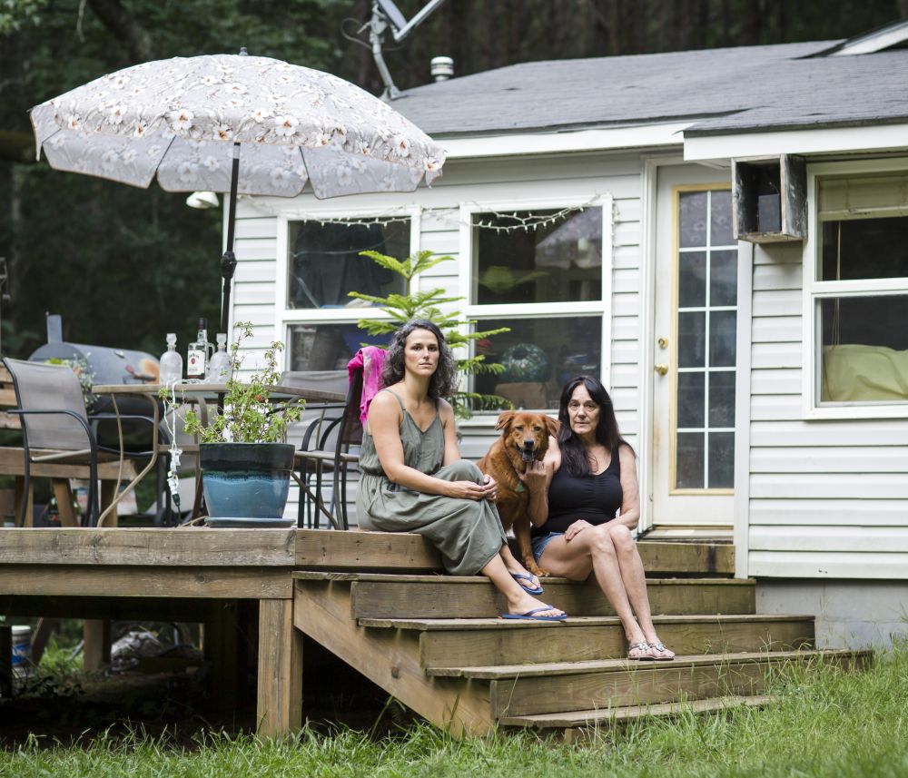 two women sat on steps outdoor a house