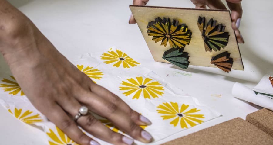 A student used a wooden stamp with daisies on a white fabric