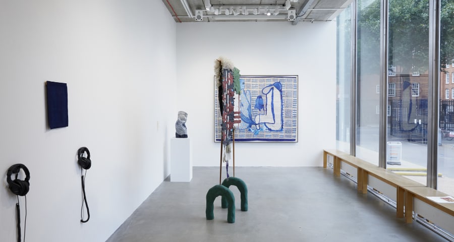 An exhibition space with paintings, sculptures and installations