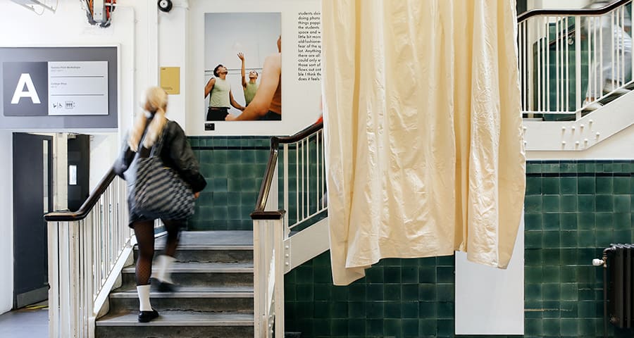 Student walking up stairs in the reception area at Lime Grove site