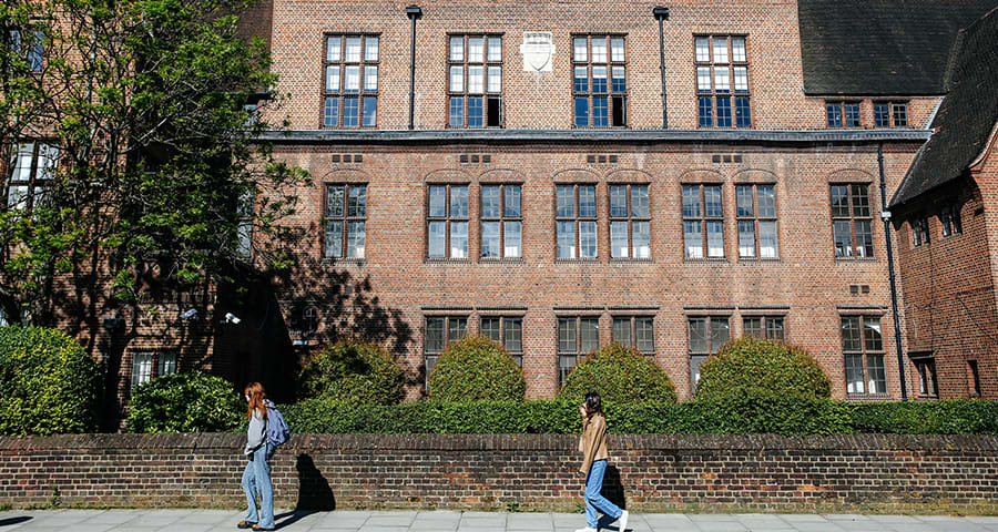 Two students walking on foot path outside of the Lime Grove site