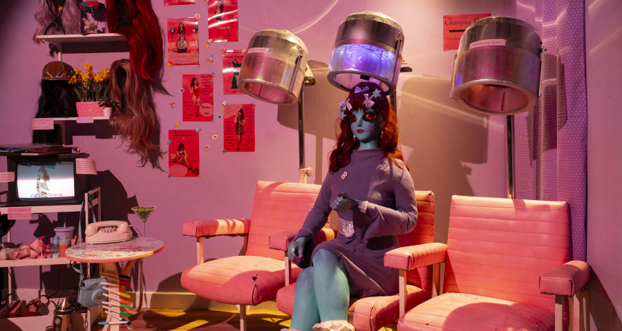 Blue alien woman sitting in pink hair salon