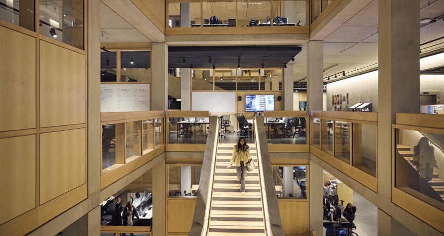 Wide angle shot of LCF's staircase, with a female walking down the stairs