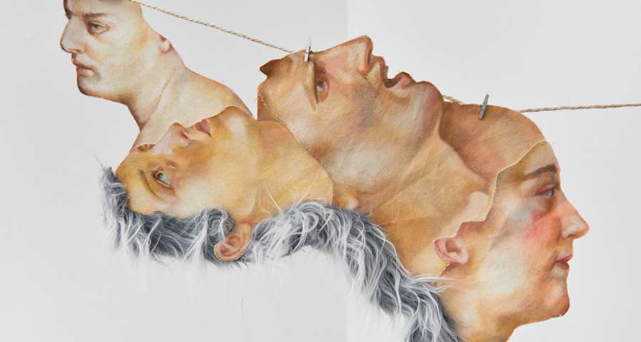 Four people's heads joined together and hanging from a rope