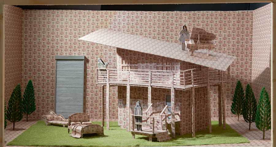 Miniature sculpture of a house with a bed and a sofa